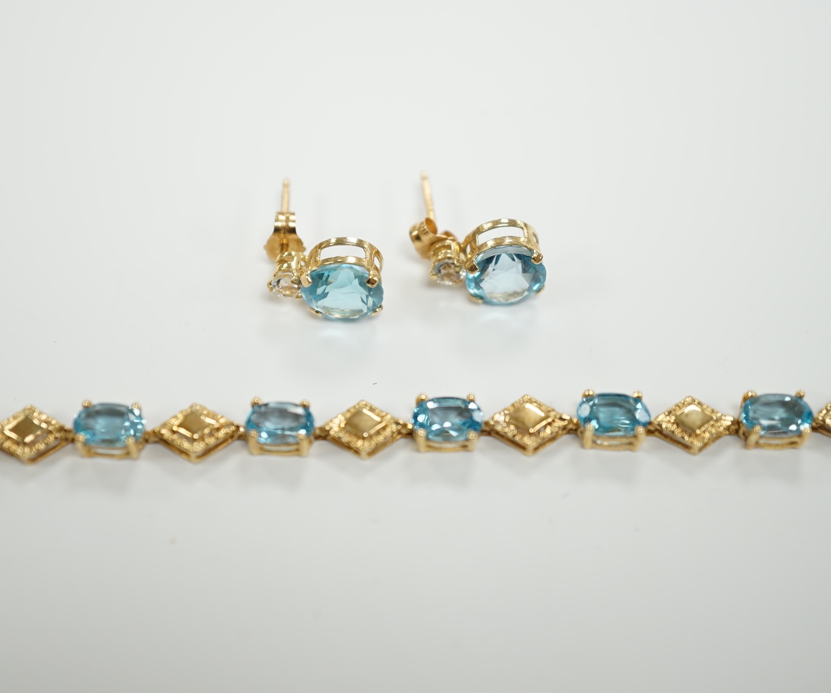 A modern 9ct gold and blue topaz? cluster set bracelet, 18.5cm, together with a pair of 9ct, blue topaz? and simulated diamond set ear studs, gross weight 6.6 grams.